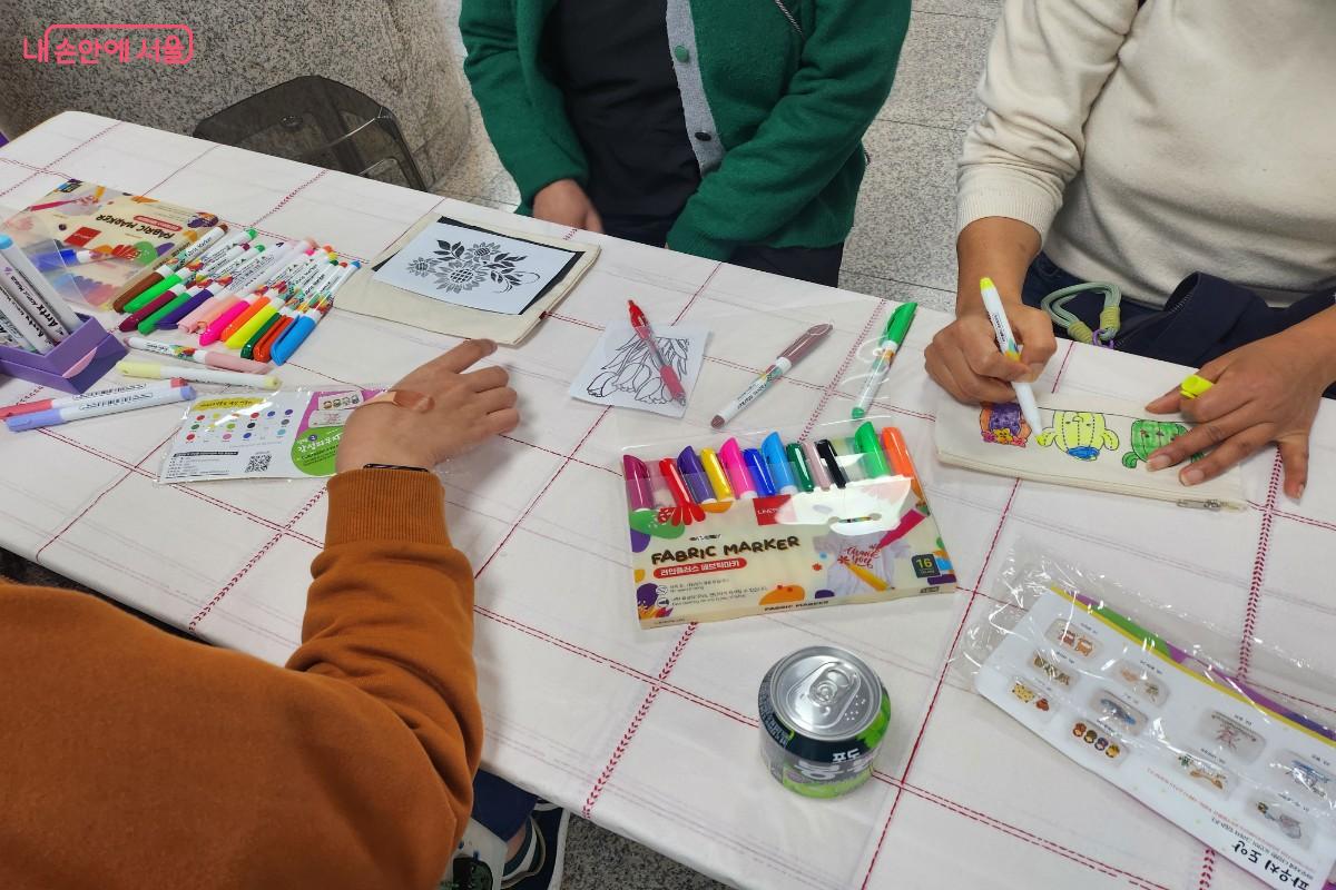 다양한 디자인의 도안에 형형색색 색칠해 나만의 파우치를 만들고 있는 모습 ©이주영