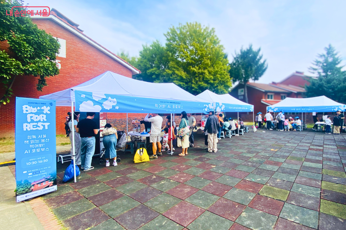 'Book for Rest' 로고가 그려진 파란색 천막의 체험 부스 앞에 여러 시민이 모여 있다. 아이들과 함께 온 가족 단위 방문객들이 다양한 체험 활동에 참여하고 있다. ©양정화