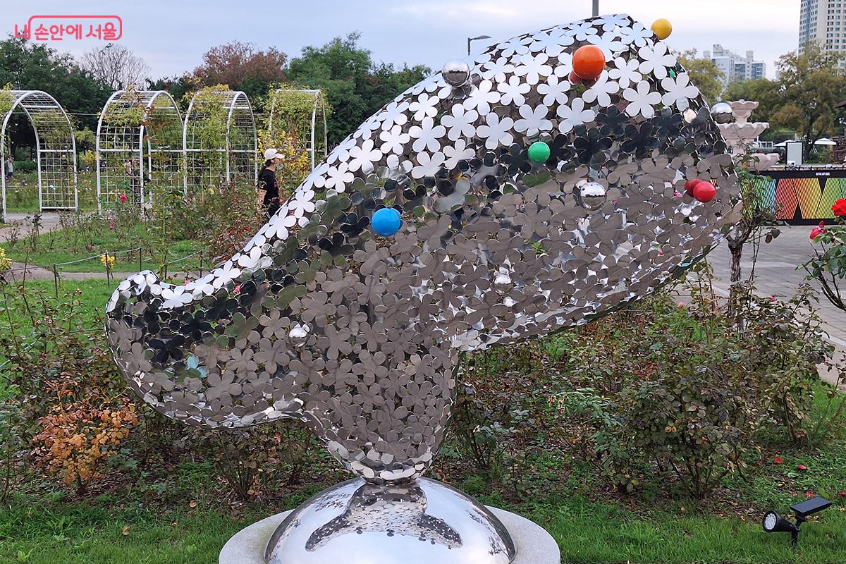 조정 작가의 '야(野) - 후' 작품은 화강석 위에 스테인리스 스틸을 이용하여 버선의 세련되고 우아한 곡선의 느낌을 강조한다.