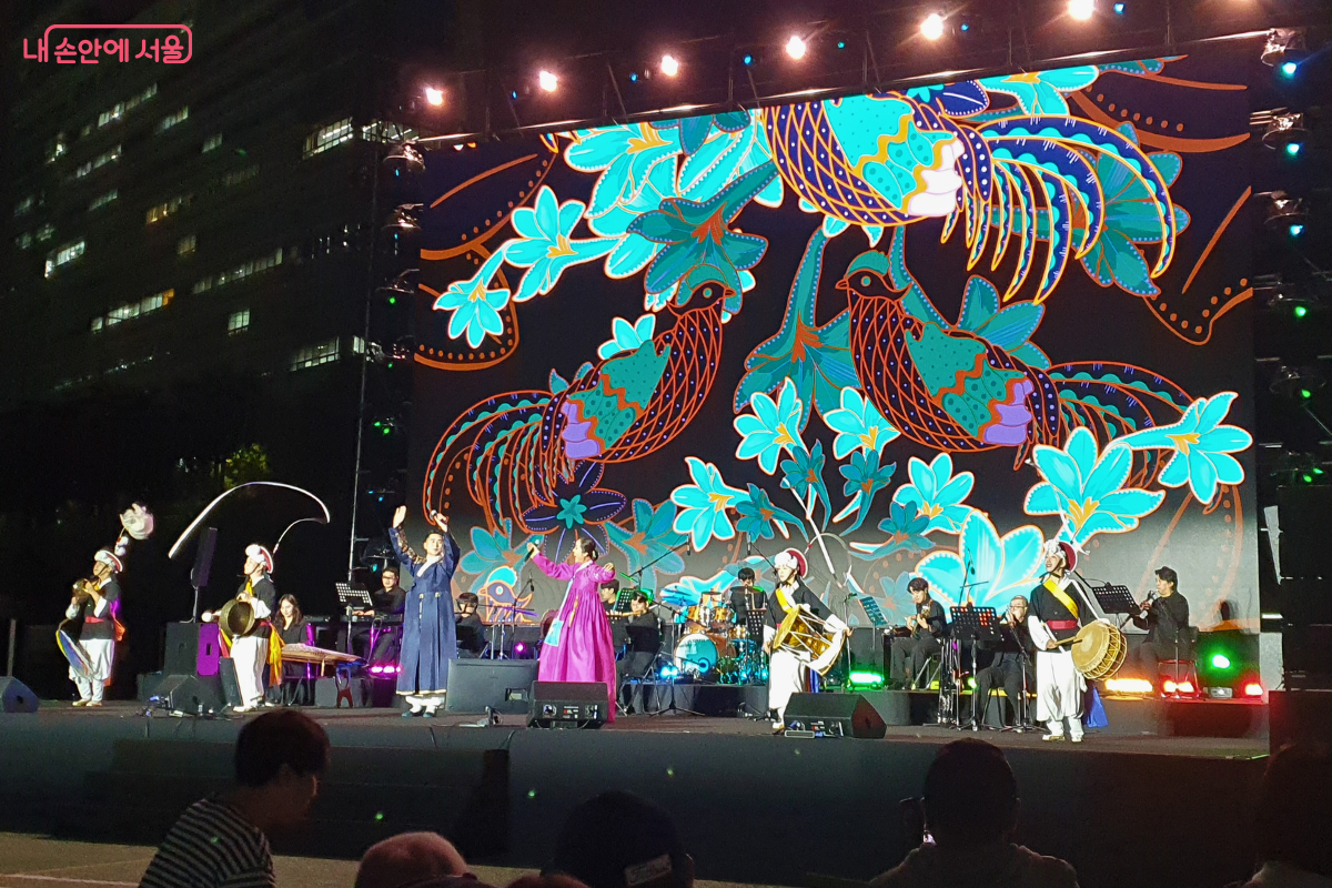 소리꾼 고금성, 박애리, 연희앙상블 ‘비단’, 남기문 국악단 등 모든 출연진이 무대에 올라 화려한 민화풍의 봉황 그림을 배경으로 마지막 곡 밀양아리랑과 진도아리랑을 함께 부르며 피날레를 장식하고 있다.