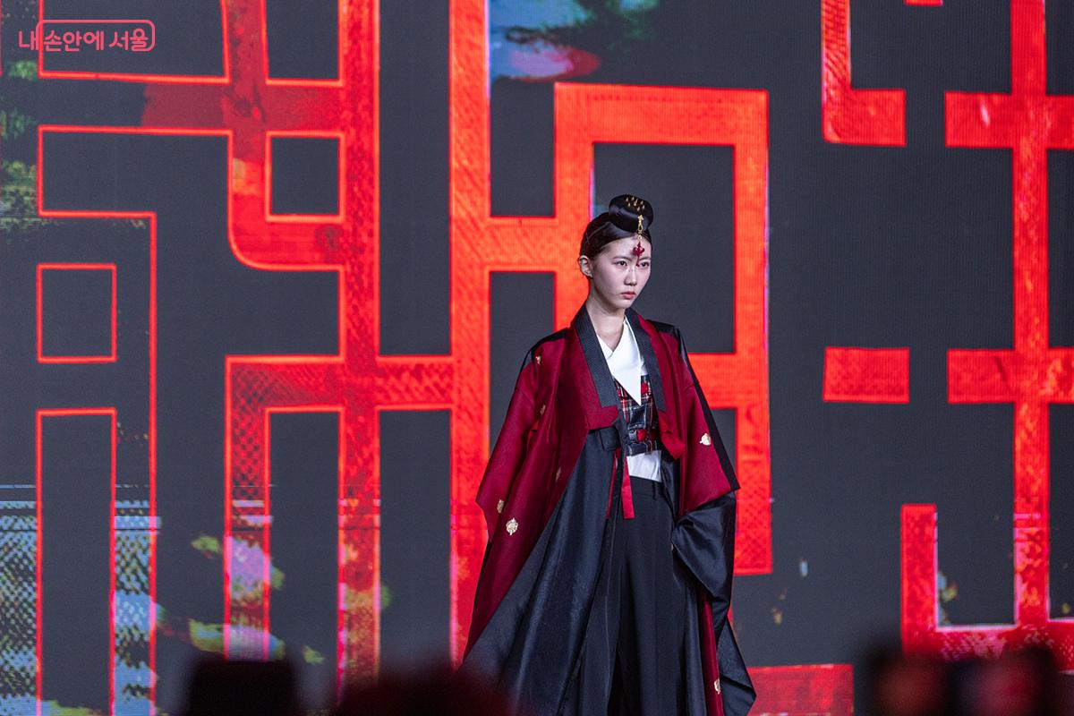 붉은빛 한복 위로 드리워진 조명과 기하학적 배경이 어우러져 강렬한 존재감을 드러낸 모델 ⓒ장신자