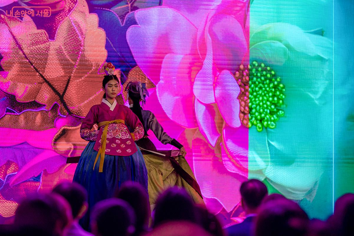 붉은 치마저고리를 입은 모델이 꽃을 배경으로 선보인 퍼포먼스. 전통과 현대의 색감이 어우러졌다. ⓒ장신자
