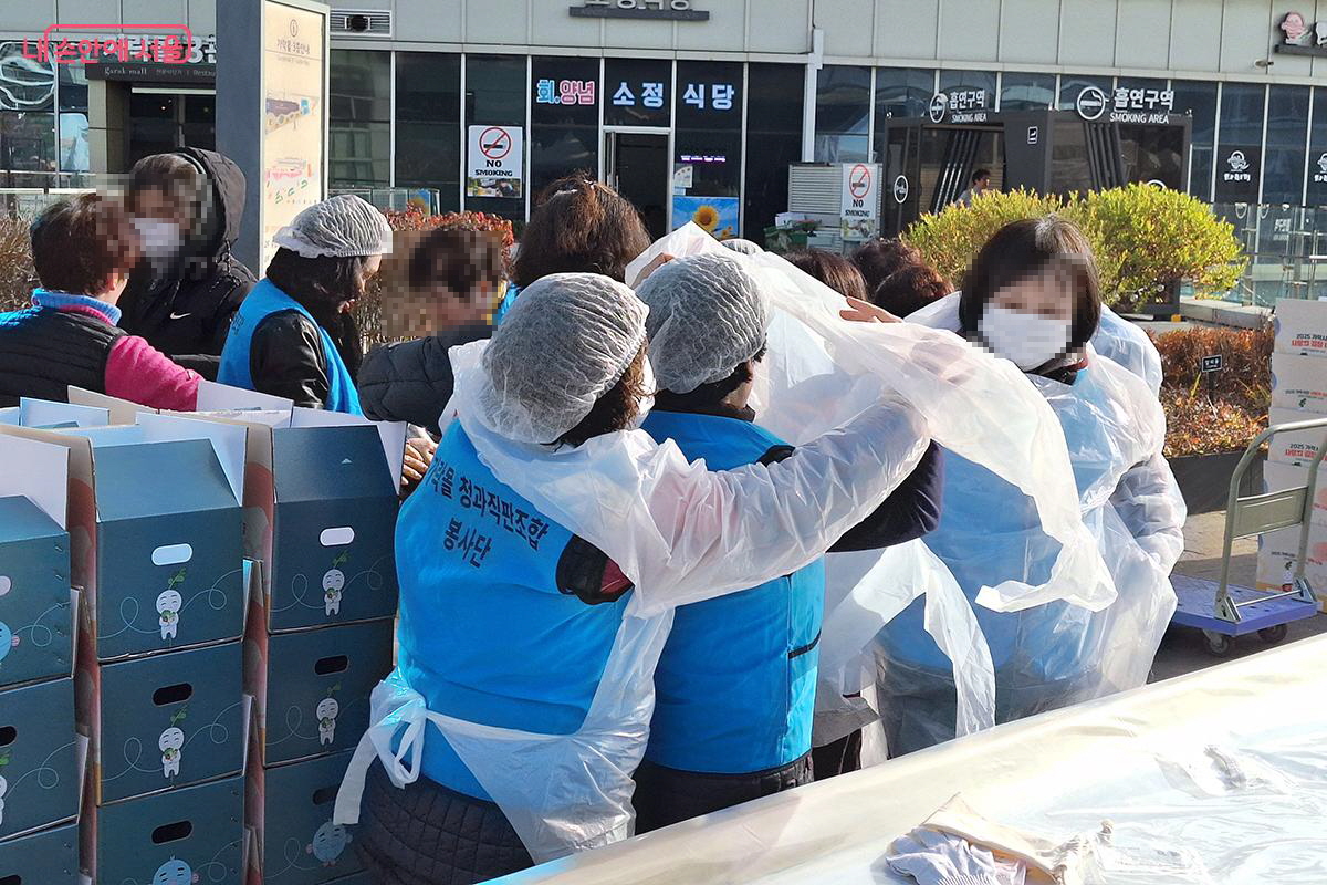 행사에 참가한 자원봉사자들이 김치 만들기 전 위생복을 착용하는 모습 &copy;정향선