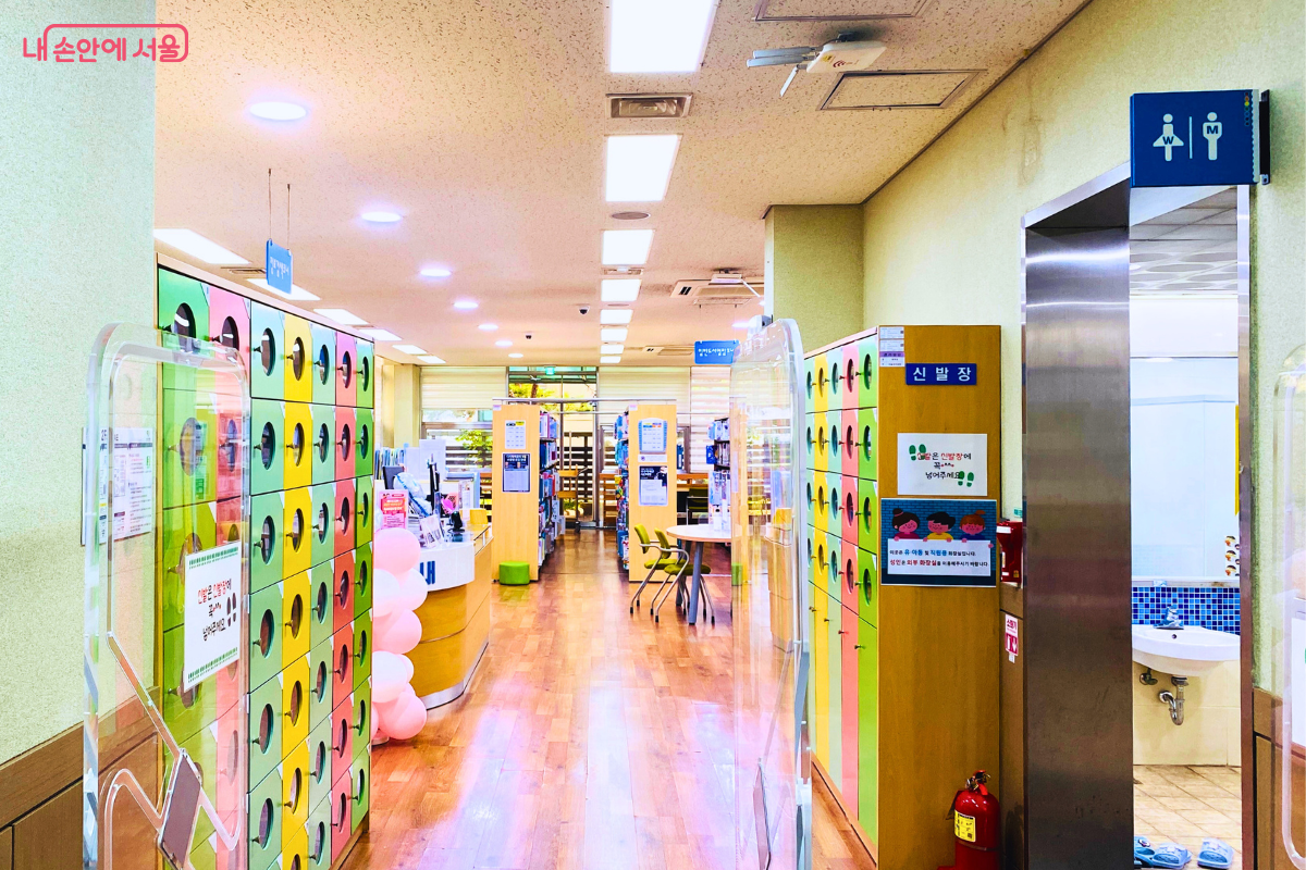 신발을 벗고 들어온 어린이열람실 내부 복도의 모습이다. 밝은 나무 바닥으로 된 복도 양옆으로 노란색, 초록색, 분홍색 등 알록달록한 개인용 신발장이 길게 늘어서 있다. ©양정화