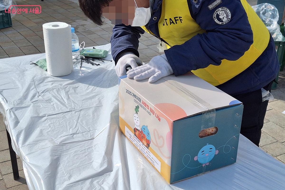 자원봉사 스태프들이 완성된 김치들을 배달 박스에 담고 있다. &copy;정향선