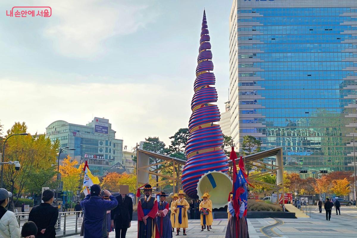 조형물 <스프링> 앞에서 외국인이 순라행렬과 함께 기념사진을 찍고 있다. &copy;조성희
