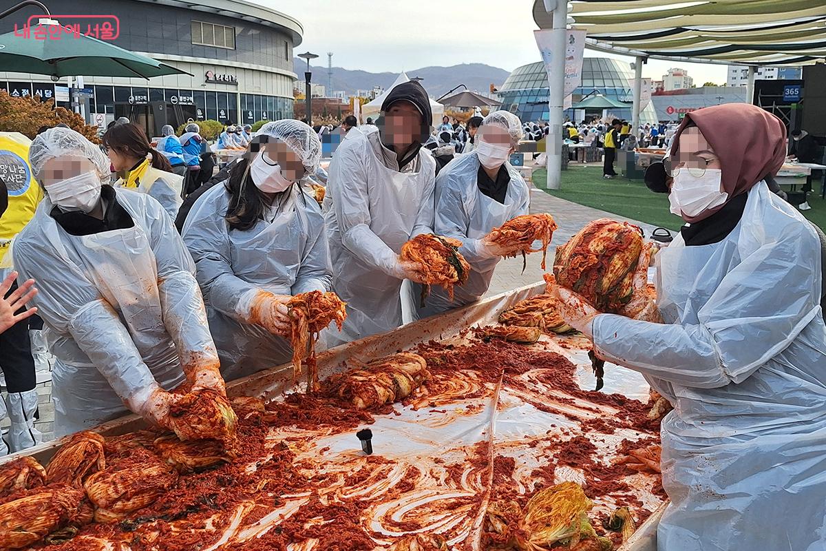 외국인 자원봉사자들이 직접 만든 김치를 자랑스레 들어보이고 있다. &copy;정향선