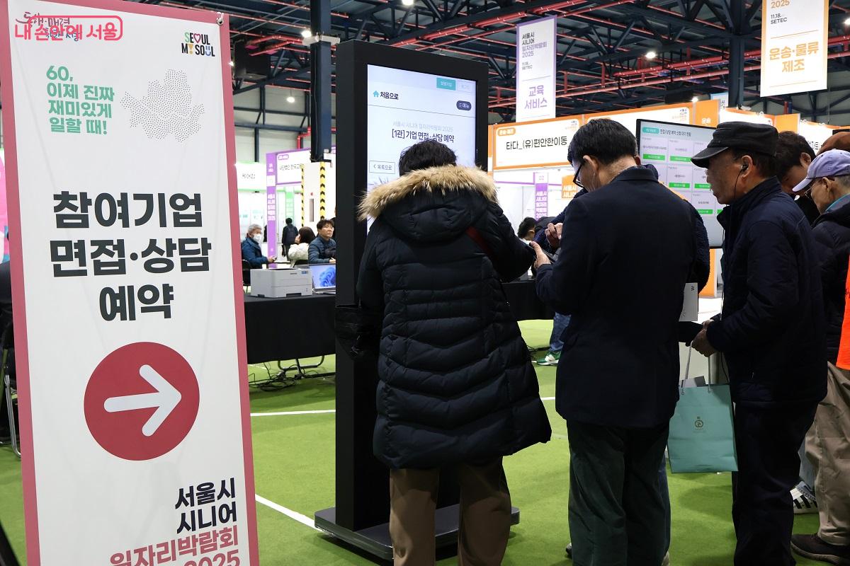 방문객들이 참여기업 면접 및 상담을 위해 스마트폰으로 예약하고 있다. ©이봉덕 