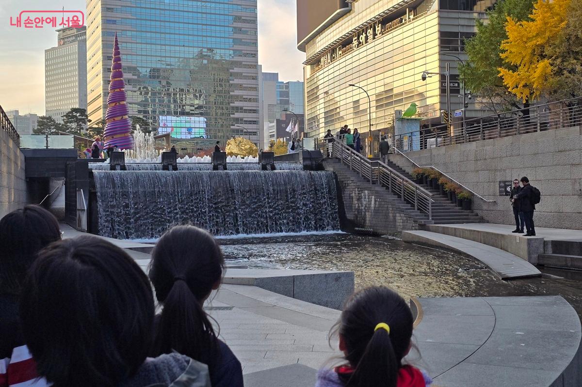 &lsquo;청계공존&rsquo; 작품 세 개가 보이는 위치에서 아이들이 청계천의 물길과 함께 감상하고 있다. &copy;조성희