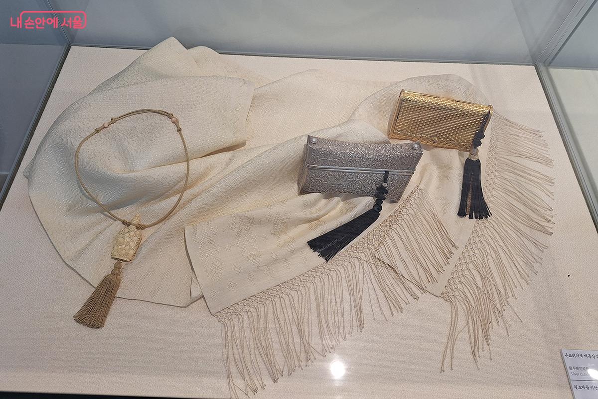 '칠보매듭 비단솔' 로 장식한 여성용 은색 손가방