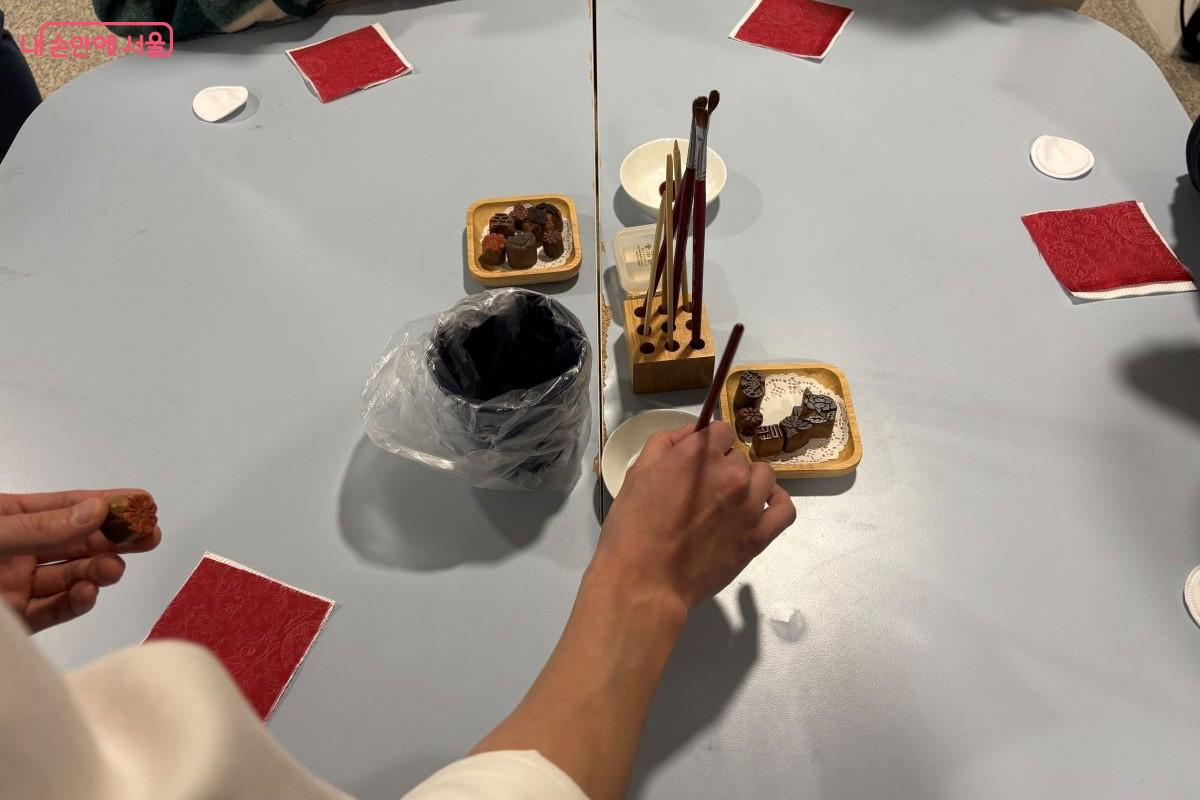 붓에 풀을 찍는 모습이다. &copy;김아름