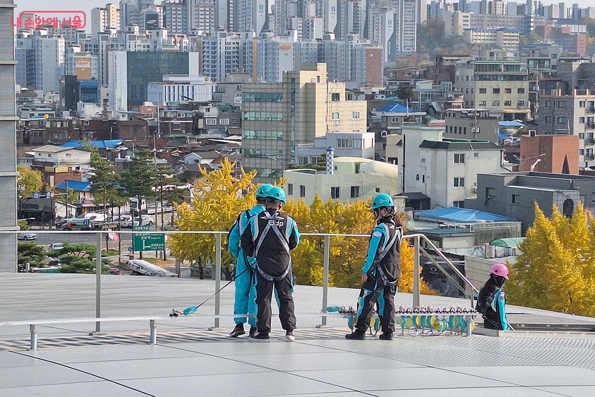 루프탑 투어가 끝나고 안전그네에 연결된 안전로프를 해제하고 있다. ©백승훈