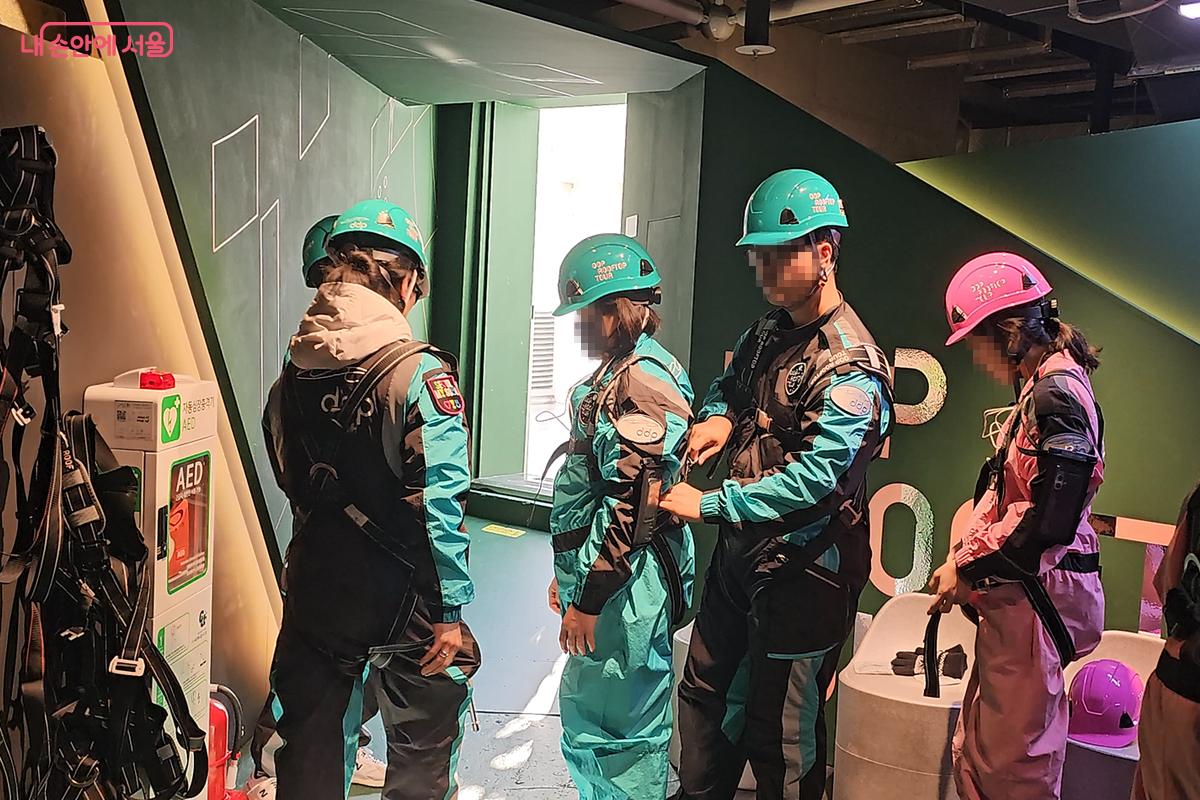 투어 참가자들이 직접 하네스를 착용하고 있다. ©오도연