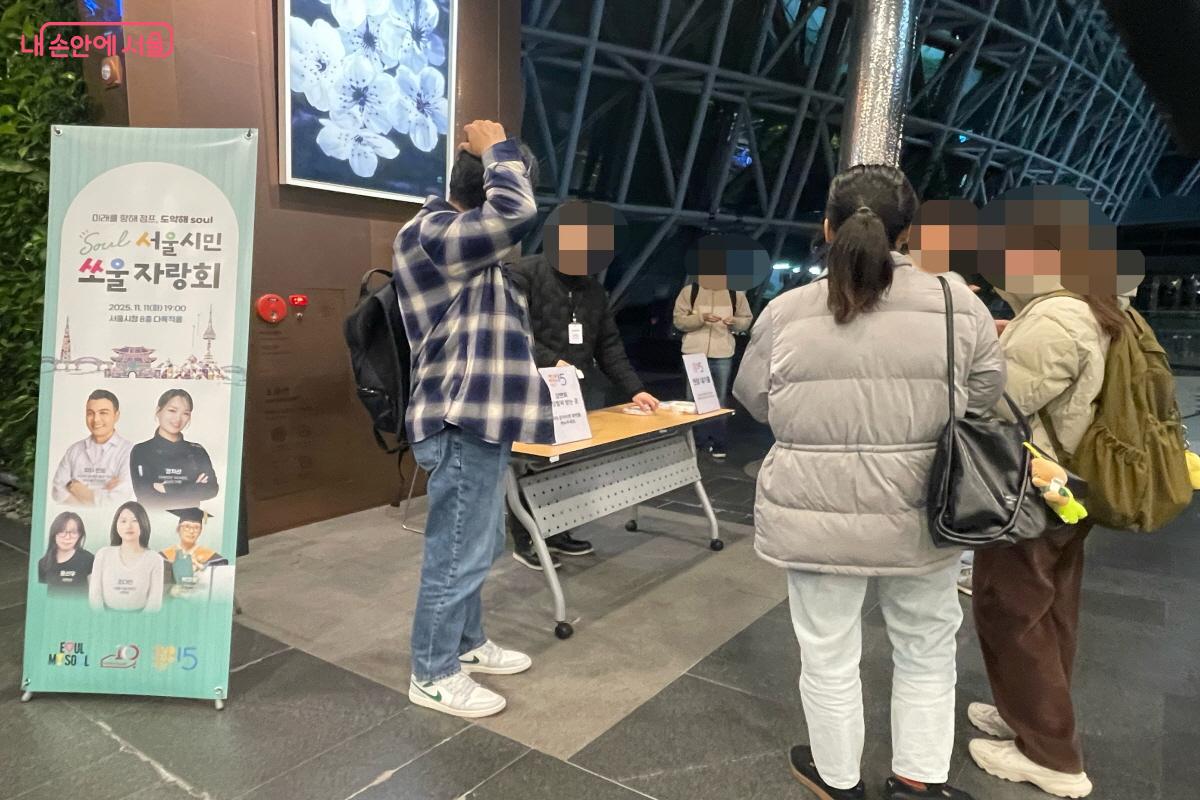 서울시청 본관 1층 로비에서 '서울시민 쏘울자랑회' 입장 팔찌를 받는 사전 신청자들 ©이정민