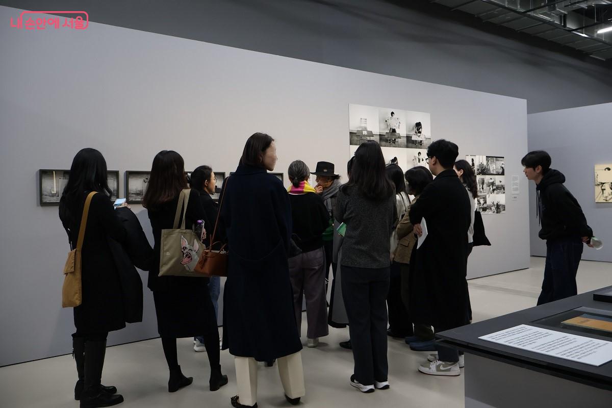 작가의 작품 설명에 귀 기울이고 있는 관람객들 ©이봉덕 