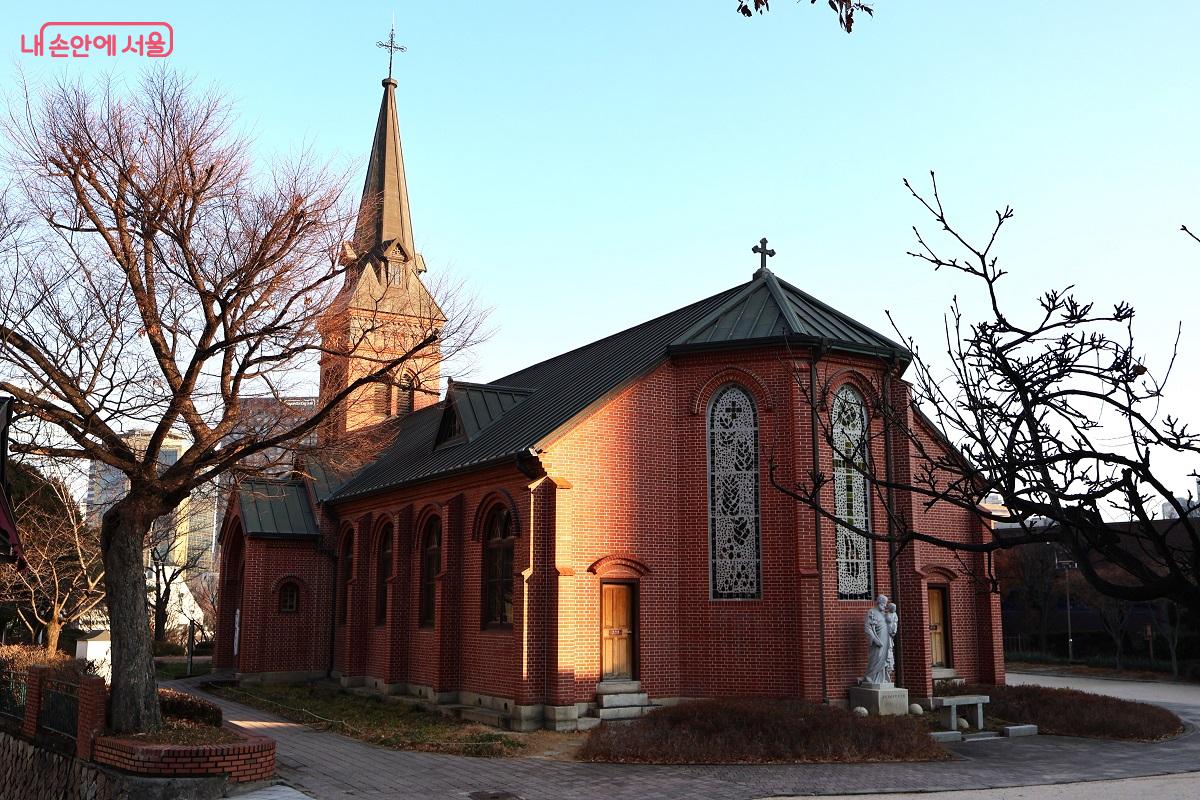 붉은 벽돌의 고딕 양식과 아담한 규모는 화려함보다는 차분함을 전하며, 조용한 골목 안 언덕 위에 한국 천주교의 시작과 순교의 기억을 담고 있다. &copy;이봉덕