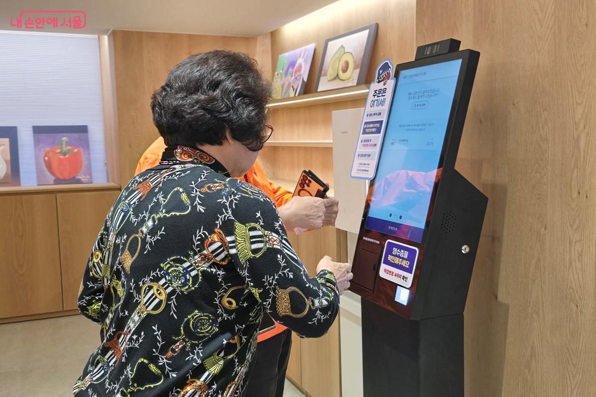 키오스크를 사용하여 음료를 주문하는 어르신 &copy;강사랑