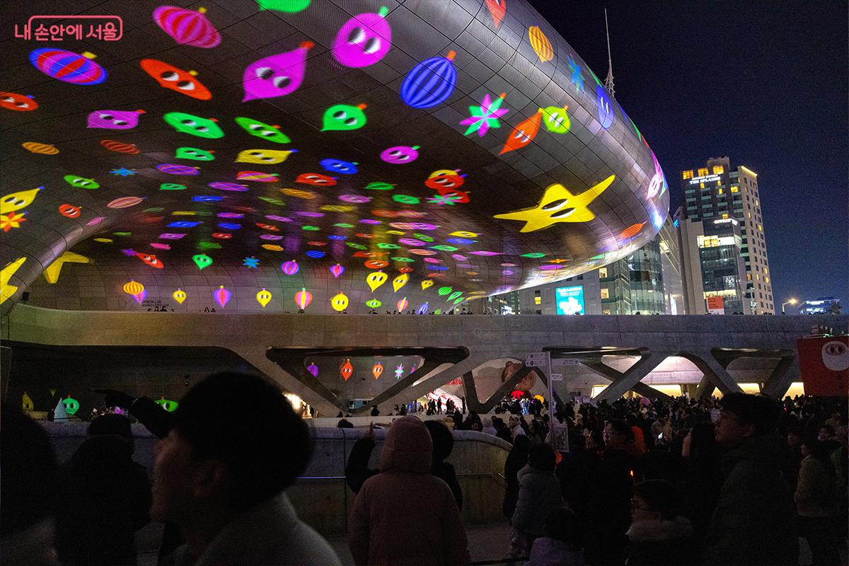 별과 캐릭터로 가득 찬 미디어파사드 아래 시민들 ©장신자