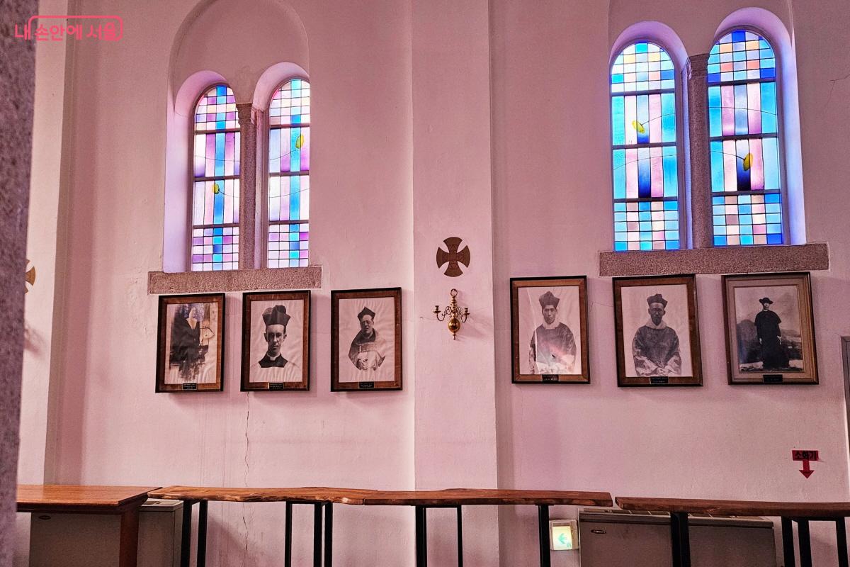 아름다운 스테인드글라스 아래 전쟁에서 목숨을 잃은 사제와 수도자의 사진이 걸려 있다. ©이선미
