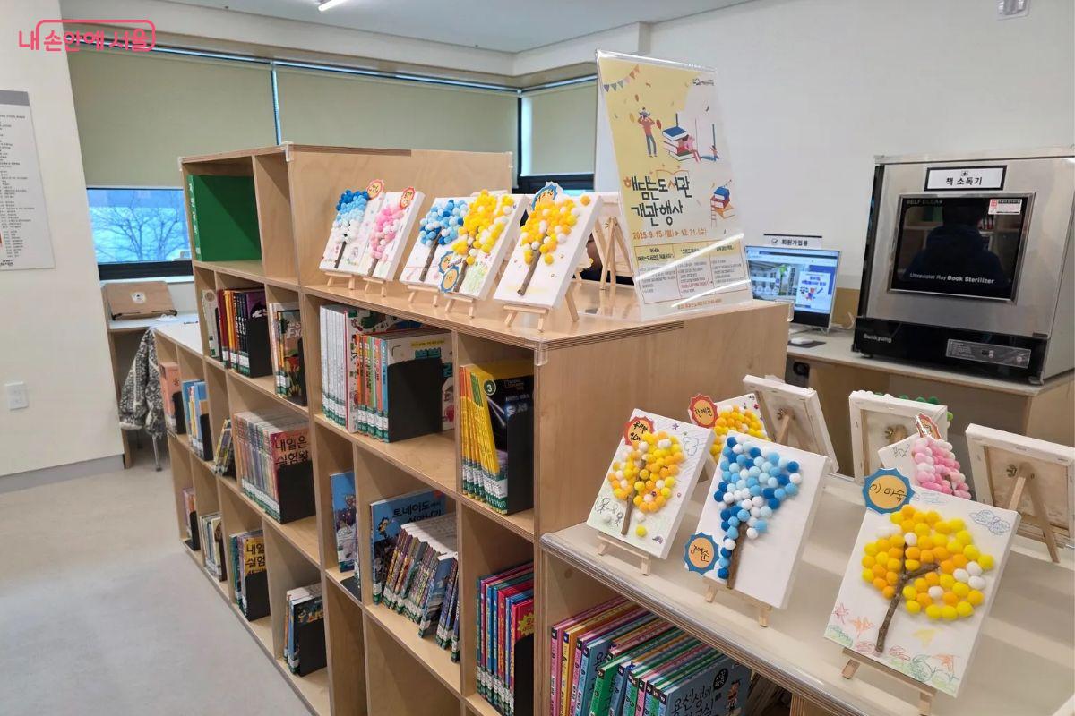 개관 행사로 진행 중인 해담는 나무가 책장 위에 진열되어 있다.