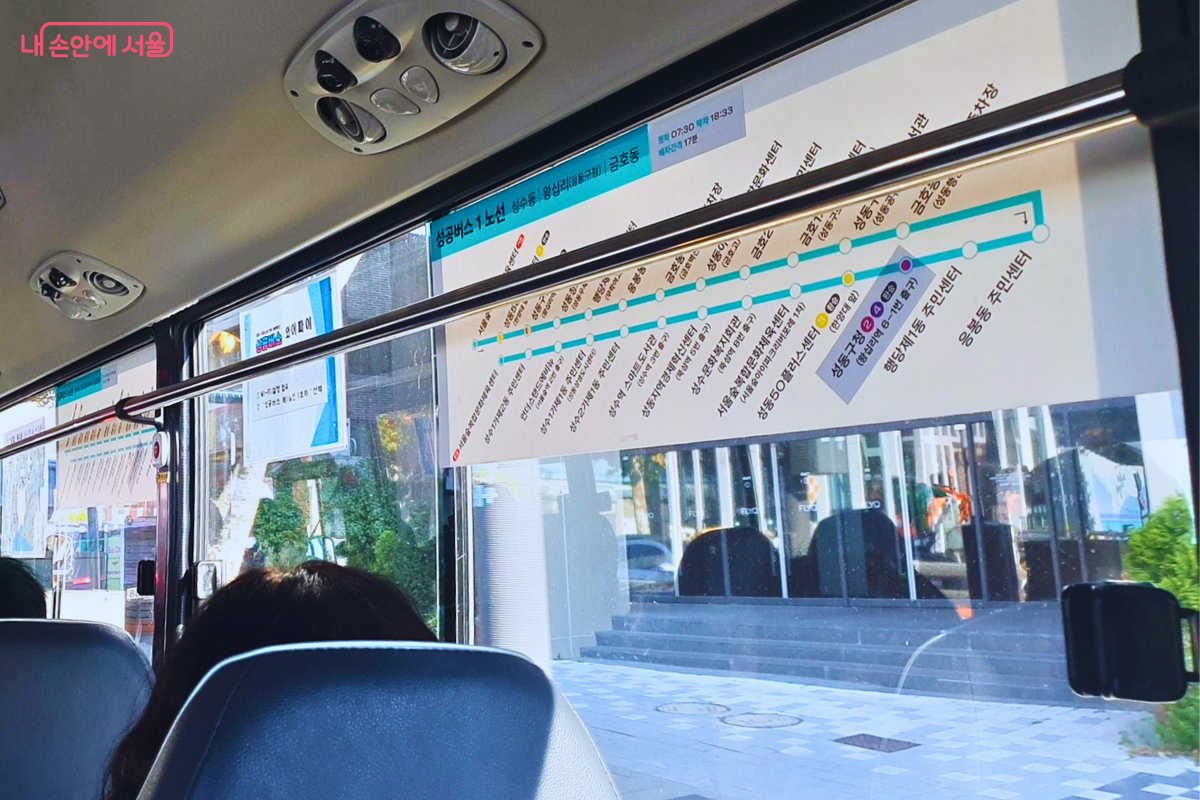 버스 내부 창문에 부착된 '성공버스 1노선' 노선도이다. 성수동, 행당동, 금호동을 잇는 주요 정거장들이 파란색 노선 위에 알기 쉽게 표시되어 있어, 승객들이 목적지까지 남은 정류장을 편리하게 확인할 수 있다. ©양정화