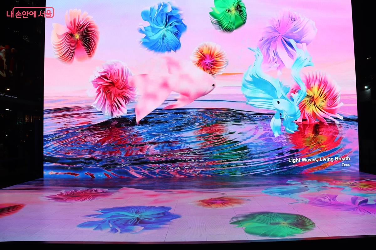 Zeus 작가의 작품 <빛의 물결, 생명의 숨>. '디지털 바다'를 배경으로 선명한 컬러 부유체의 정적인 아름다움과 역동적으로 유영하는 빛의 물결을 만날 수 있다. &copy;정향선