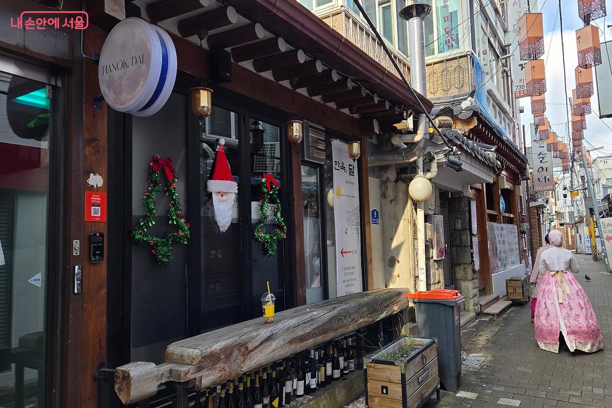 한복을 입은 외국인이 전통 한옥 음식점이 있는 서촌 음식 거리를 걷고 있다. &copy;이상돈