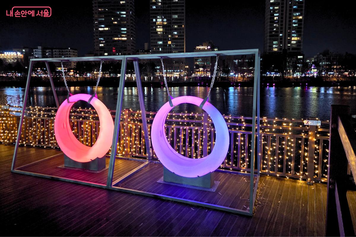신비로운 보랏빛 조명을 내뿜는 석촌호수 수변 데크 원형 그네 포토존 &copy;양정화