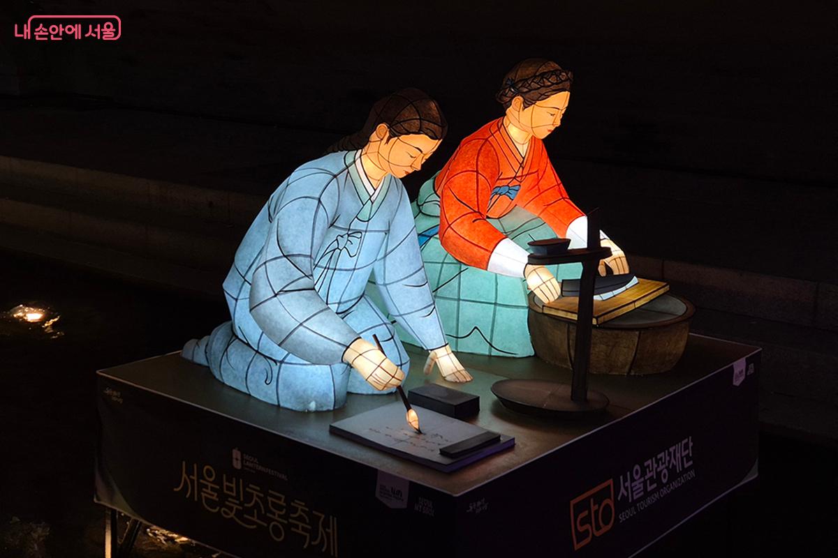 어두운 밤에 떡을 써는 어머니와 글을 쓰는 한석봉 &copy;이혜숙