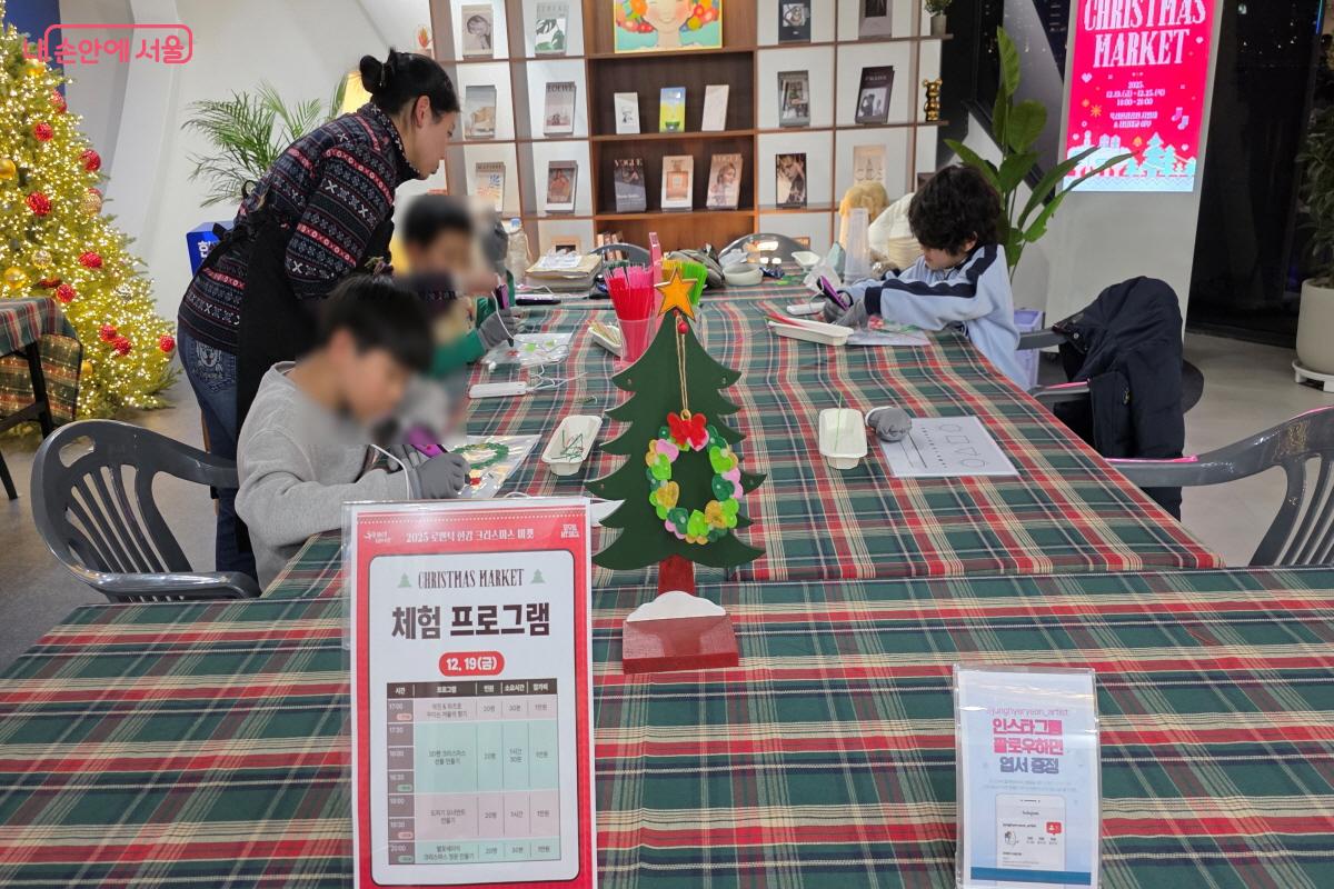 크리스마스 트리 만들기에 집중하고 있는 어린이 참여자들 ⓒ이선미