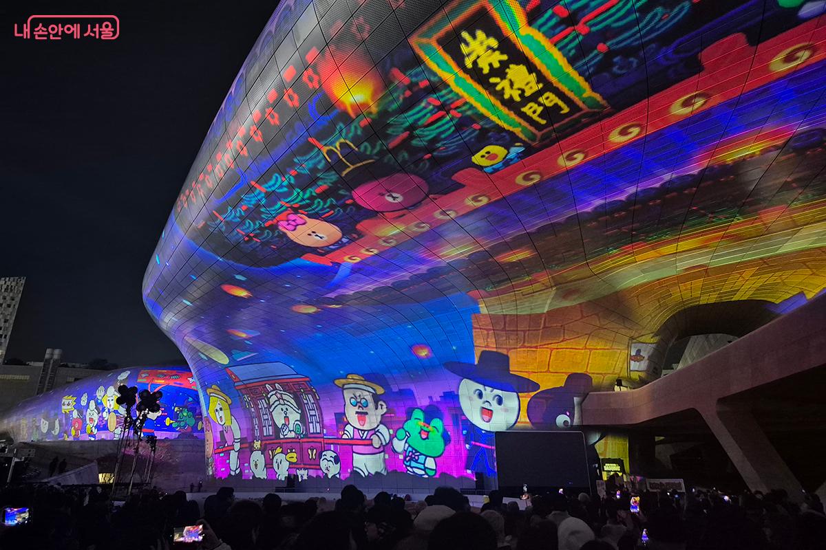 숭례문 앞을 전통 갓과 패랭이 모자를 쓰고 지나가는 라인 캐릭터들의 모습 &copy;정향선