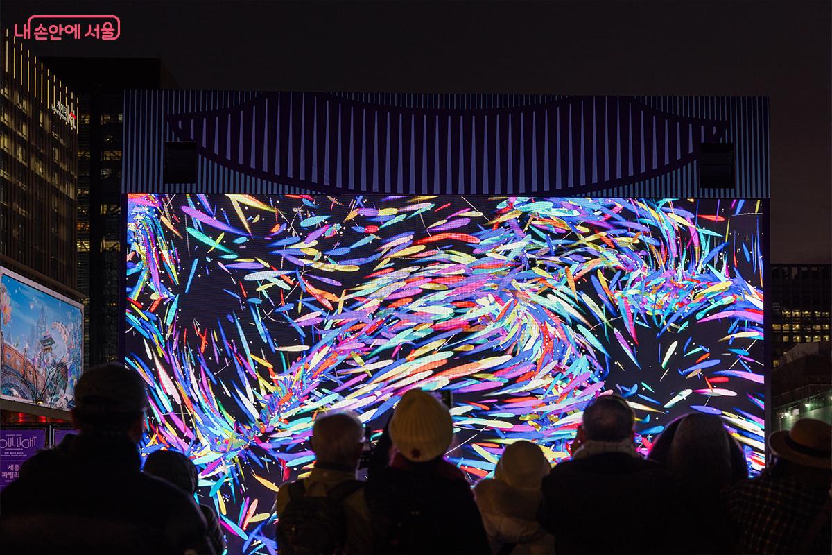 미디어아트가 펼쳐지는 대형 스크린 앞 관람객ⓒ장신자