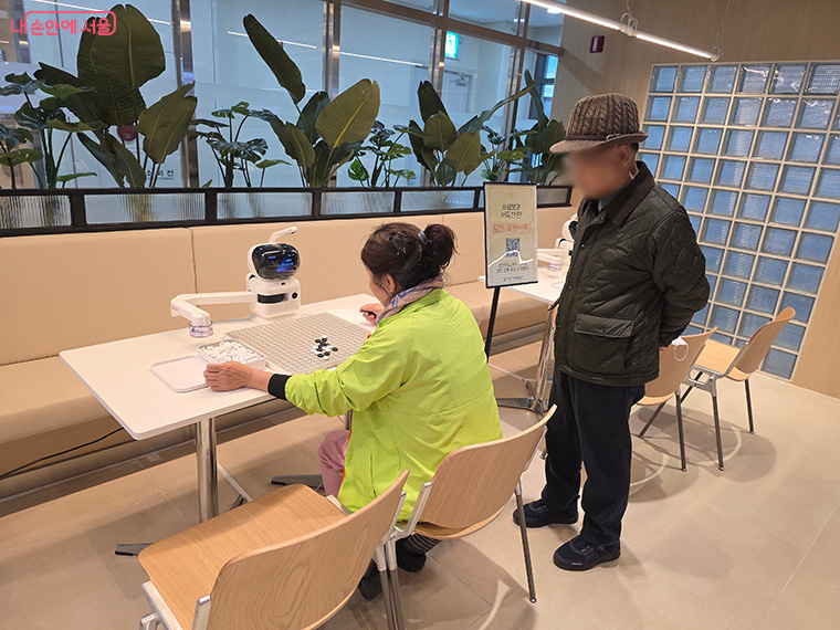 디지털동행플라자 이용 시민이 AI로봇과 바둑을 두고 있다.
