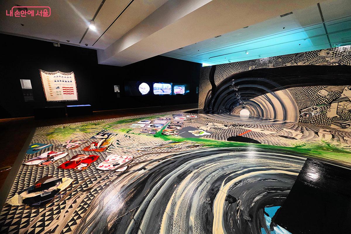 끊임없이 변화하는 지형이 담긴 지도를 배치하여 열린 교류를 의미하는 작품과 세 번째 섹션 '그것, 양서류'.&copy;이정민