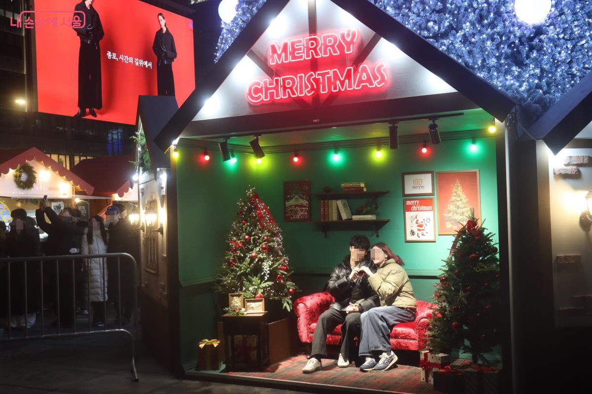 포토존에서 크리스마스 마켓을 추억하는 연인들