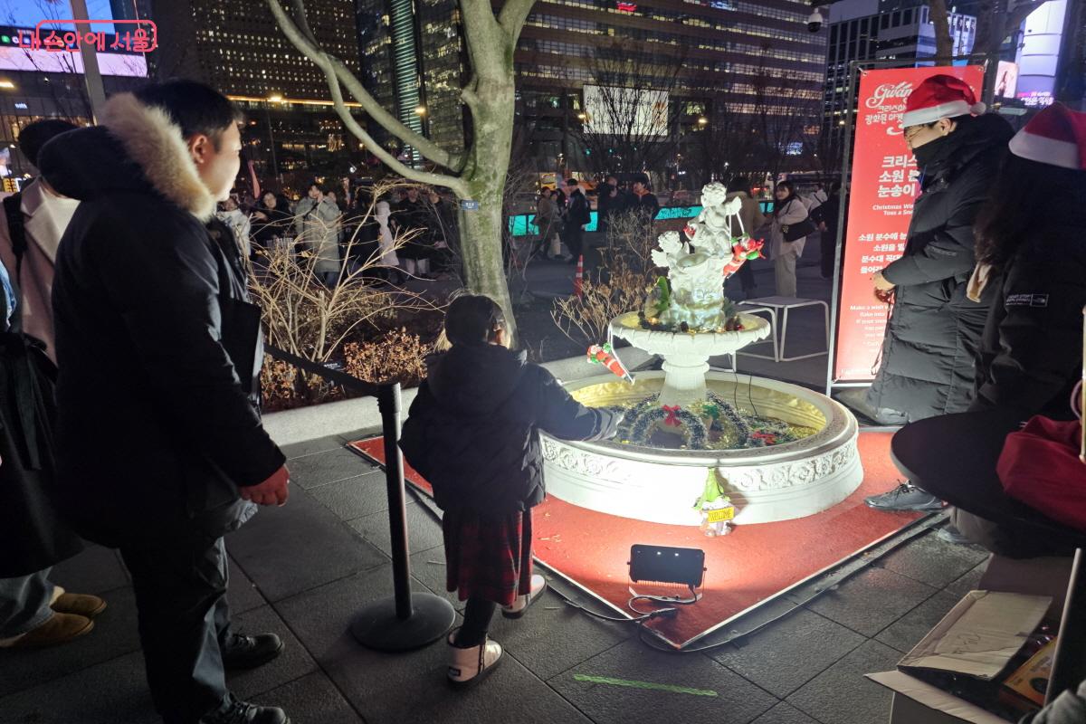 &lsquo;소원 분수에 눈송이 넣기&rsquo; 이벤트가 진행되어 많은 시민들이 참여하고 있었다. &copy;염지연