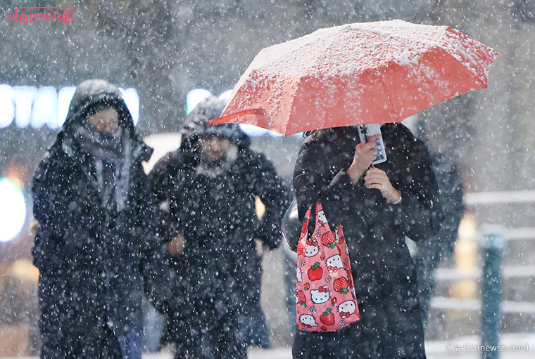 눈 내리는 거리를 걷는 시민들