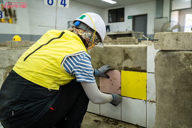 서울시 기술교육원 훈련생이 타일 시공 마감 실습을 진행하고 있다.
