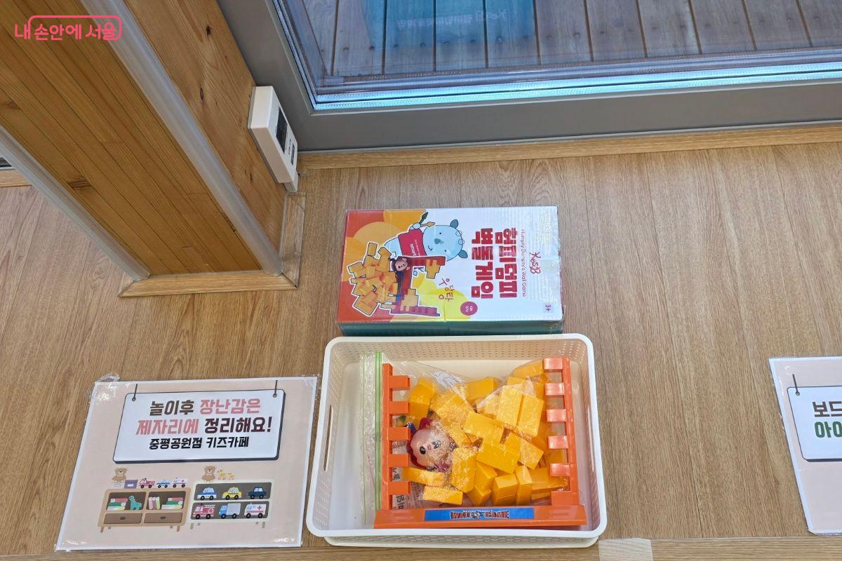 아이들이 가지고 논 장난감을 스스로 정리할 수 있도록 안내문이 붙어있다.