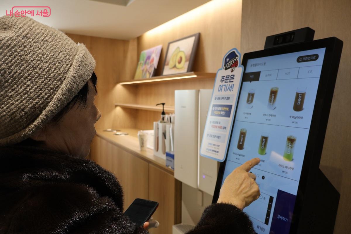 키오스크 교육을 받았다는 한 방문객이 키오스크를 이용해 무료 음료를 척척 주문하고 있다. &copy;이봉덕