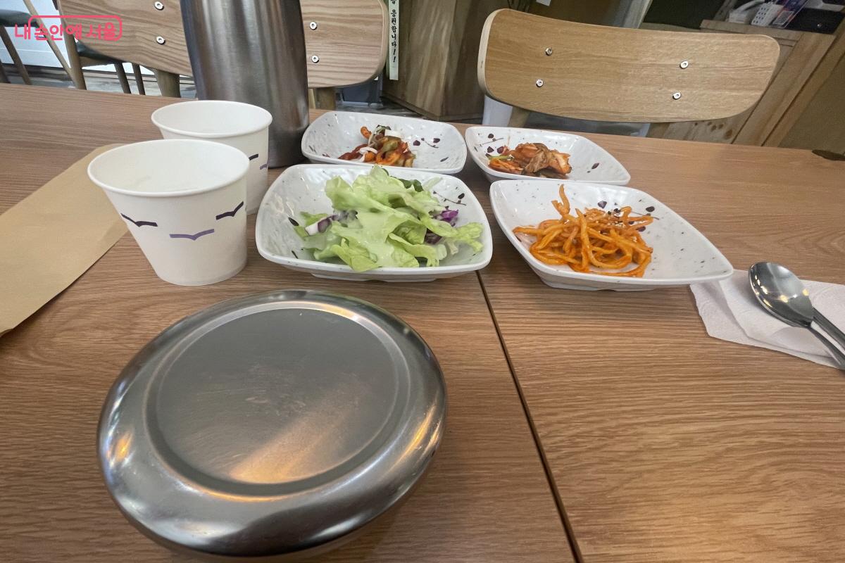 먹음직스러운 반찬들과 손님을 배려한 따뜻한 물 한 잔이 함께 놓인 테이블 &copy;이정민