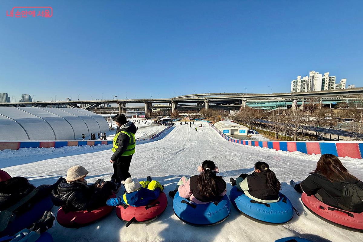 눈썰매를 타기 위해 차례를 기다리는 사람들로 활기가 가득한 뚝섬한강공원 눈썰매장 슬로프 전경 ©김미정