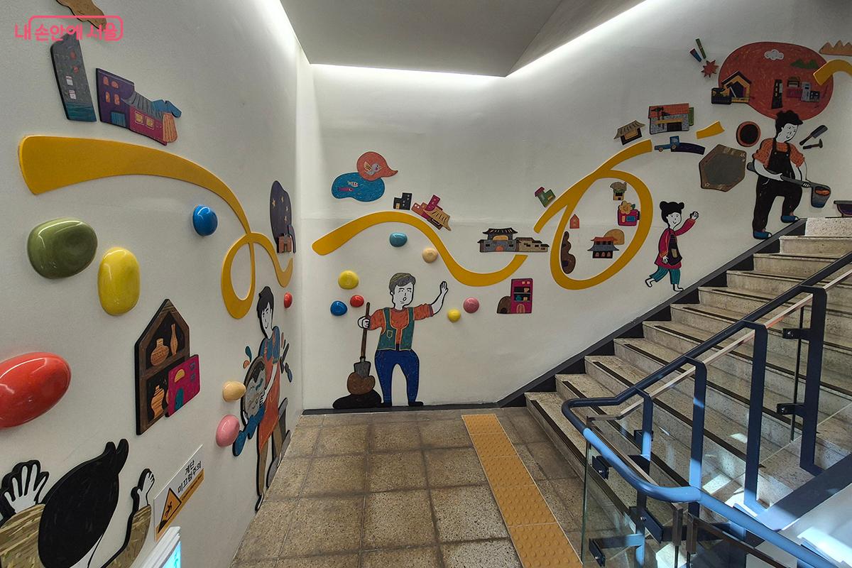 &lsquo;어린이박물관&rsquo;으로 올라가는 계단에 공예품들이 만들어지는 과정과 공예가들의 노고가 애니매이션으로 표현되어 있다. &copy;백승훈