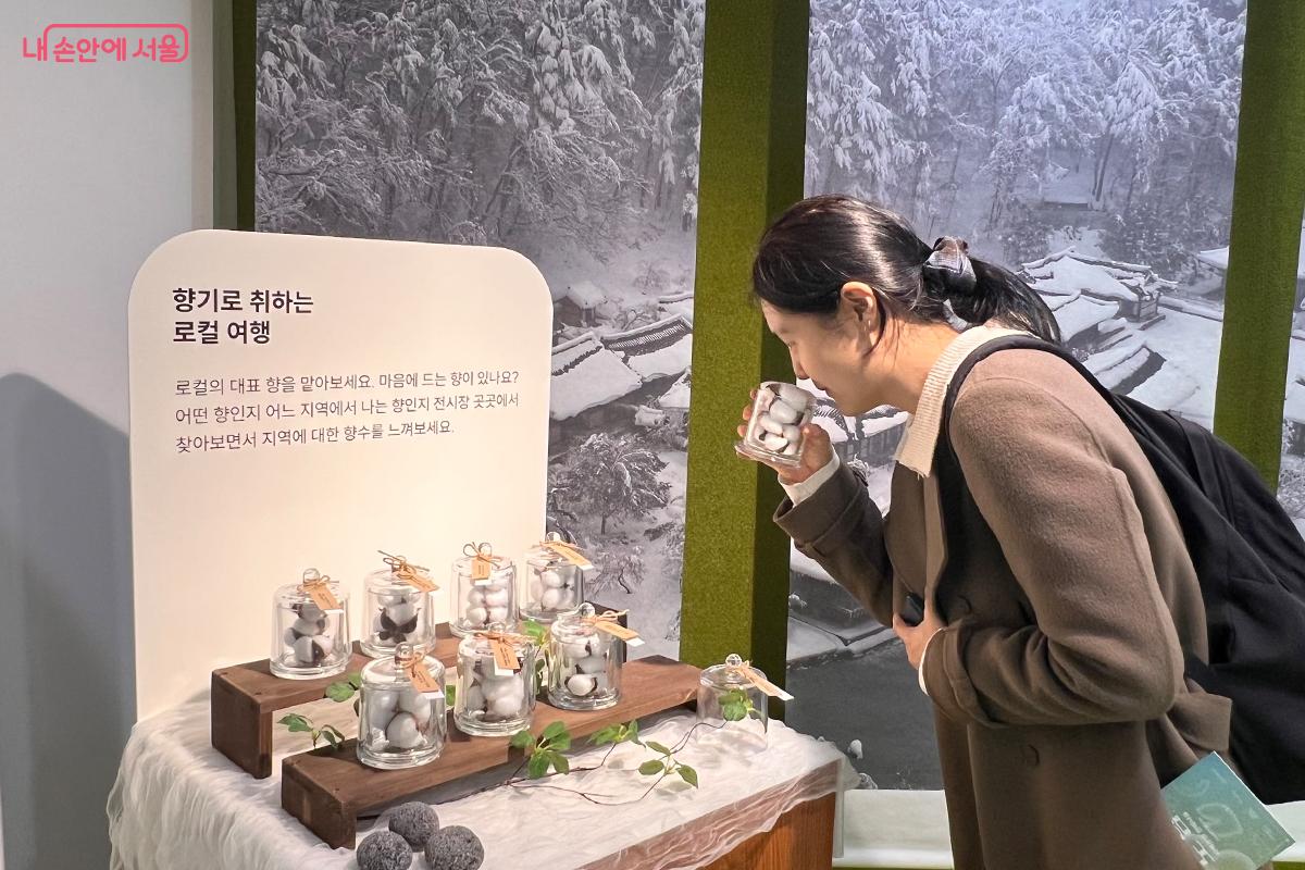 유리병에 담긴 지역 고유의 향기를 맡으며 전시를 감상하는 모습 ⓒ이다현