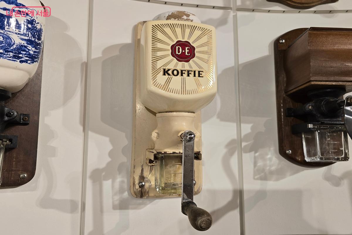 당시 신문 광고와 함께 전시된 프랑스의 벽걸이형 도자기 그라인더 &copy;강사랑