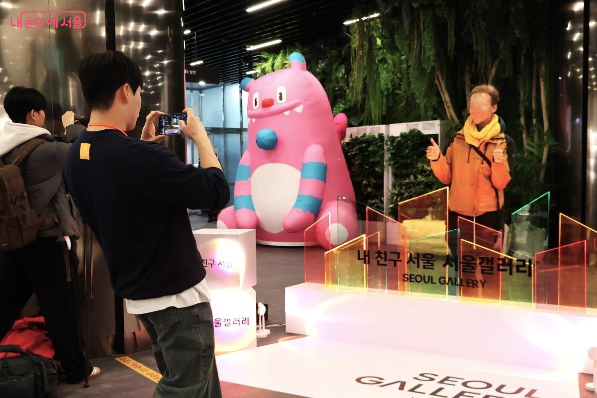 스위스에서 왔다는 한 외국인이 환한 얼굴로 서울갤러리 포톤존에서 기념 사진을 남기고 있다. 행사요원이 돕고 있다. &copy;이봉덕  