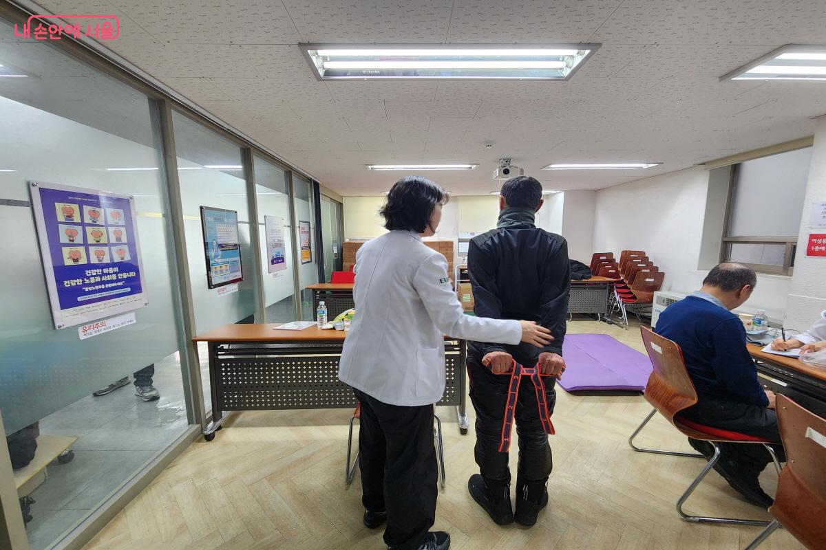 이동노동자가 밴드를 이용해 스스로 할 수 있는 스트레칭 동작을 배우고 있다. &copy;윤혜숙