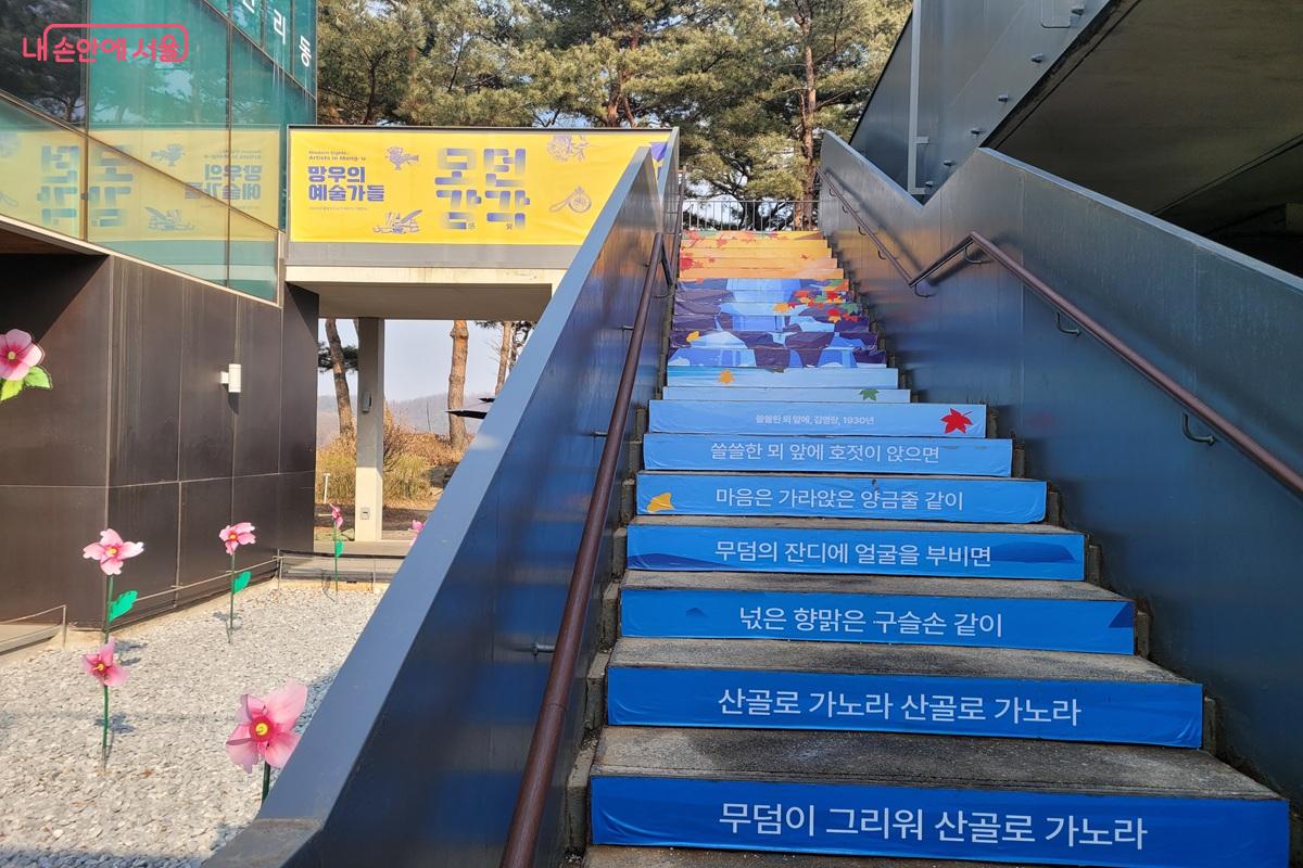 &lsquo;모던감각: 망우의 예술가들&rsquo; 전시 안내와 함께 시 구절이 적혀 있다. &copy;조연