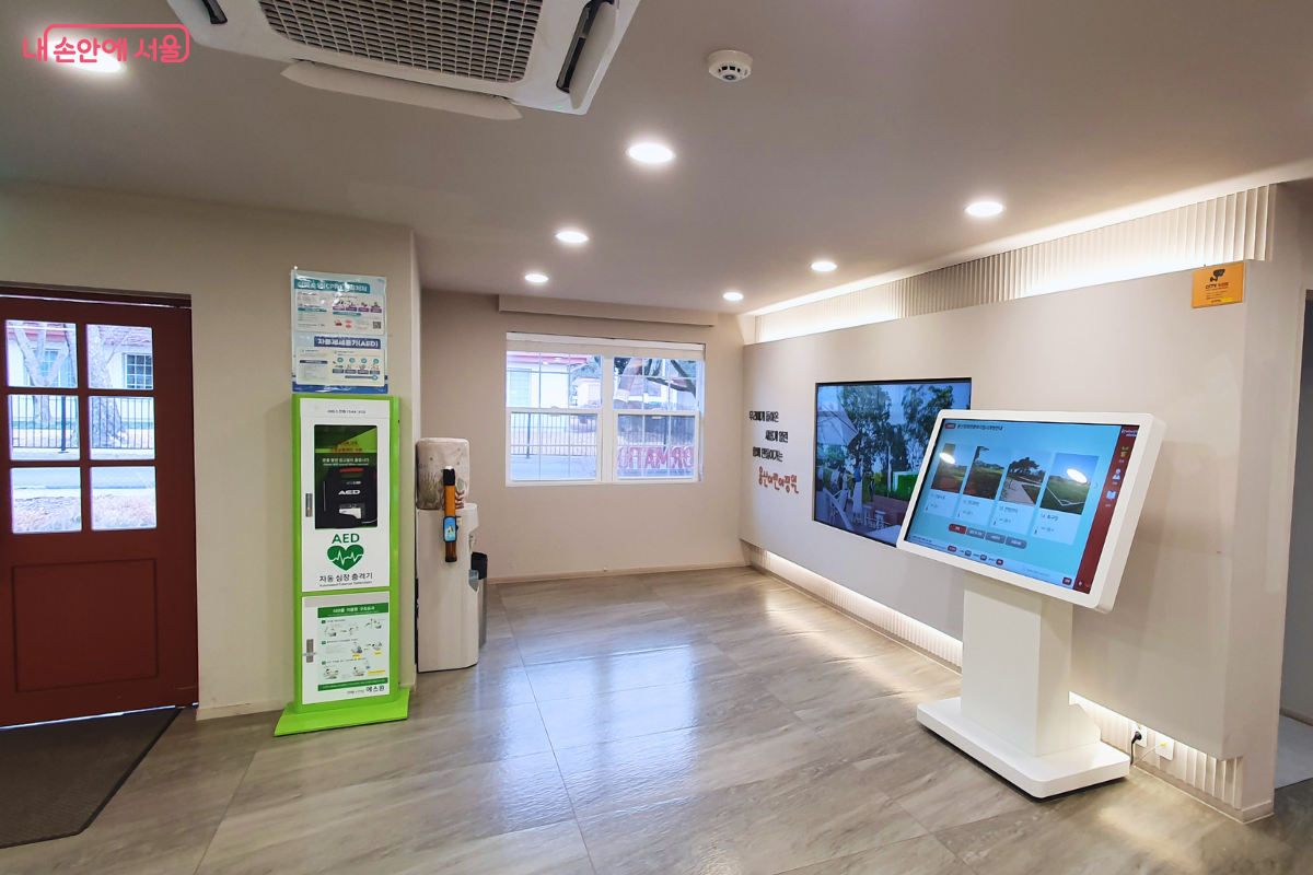 종합안내센터 내부 모습이다. 왼쪽에는 초록색 자동심장충격기(AED) 보관함이 있고 오른쪽에는 시설 안내용 대형 디지털 키오스크가 설치되어 있다.