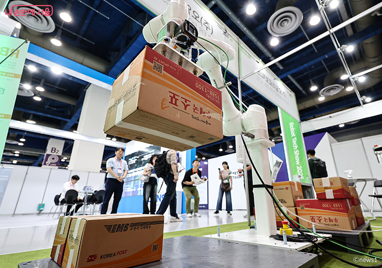 서울의 한 박람회장에서 관람객들이 로봇을 활용한 물류시스템 시연을 살펴보고 있다.